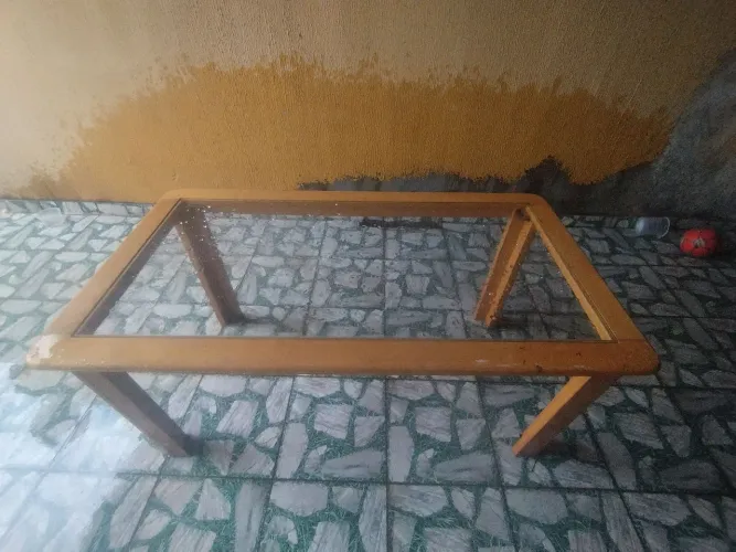Mesa de madeira com tampo de vidro.