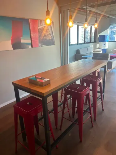 Mesa alta em madeira com 3 bancos vermelhos