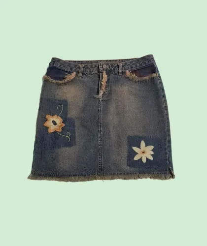Saia jeans modelo reto com detalhes de bordados e desfiados