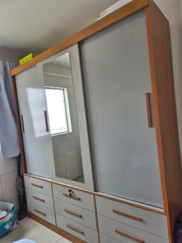Guarda roupa com 9 gavetas e espelho.