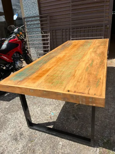 Mesa com base em ferro feita com madeiras de demolição 