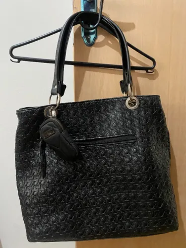 bolsa de ombro, reconhecível pelo padrão texturizado com o monograma da m