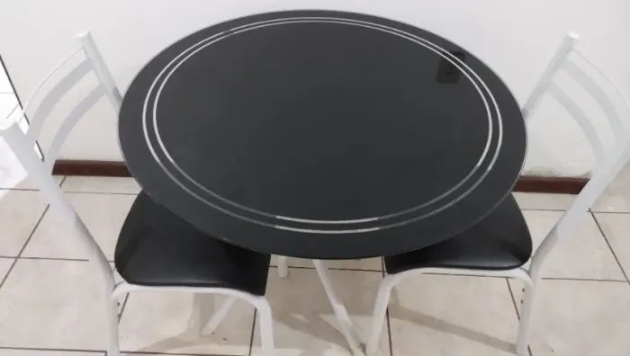 Mesa com tampo em vidro e 2 cadeiras.