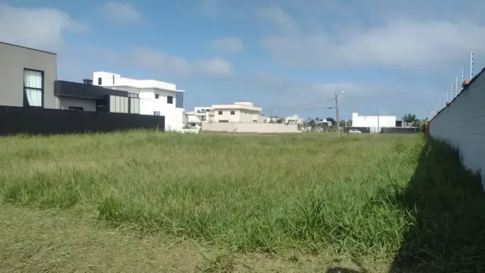 Terreno em condomínio fechado flora rica 2, lado praia a 500 metros do mar em rua calçada