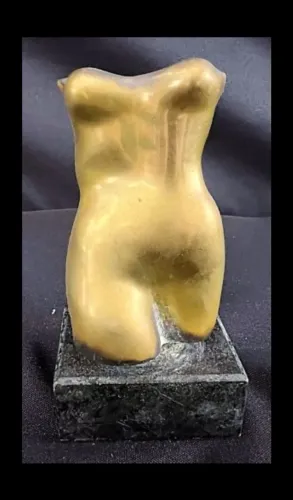 Escultura de bronze representando dorso e busto feminino com base de pedra