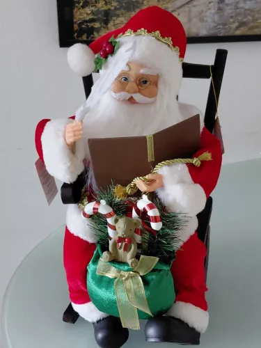 Belíssimo Papai Noel na cadeira de balanço de madeira