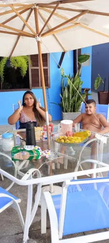 Mesa de vidro com seis cadeiras e guarda sol