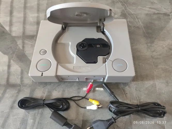 PlayStation 1 fat com controle lendo normalmente.