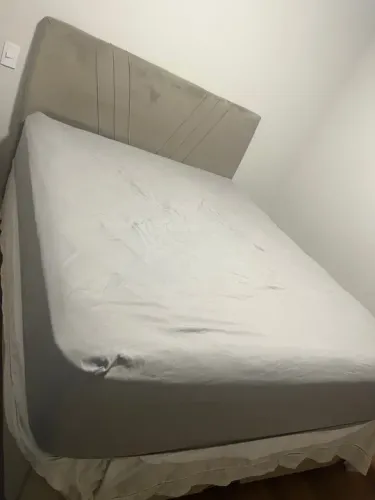 Cama Queen baú com colchão e cabeceira.
