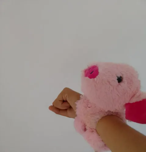 Porquinho de pelúcia para usar como pulseira ou na porta