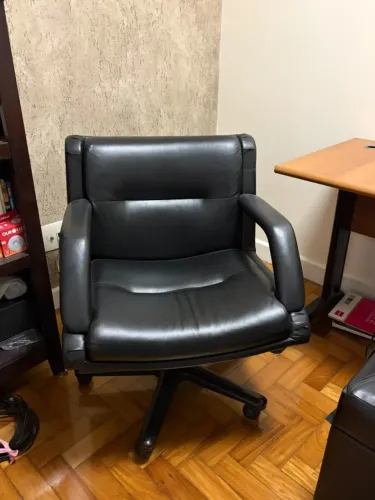 Cadeira de escritório preta estofada com braços e rodinhas