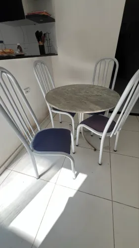 mesa redonda com tampo de granito e 4 cadeiras de metal tubular