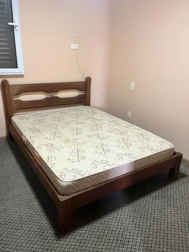 Cama de madeira padrão com colchão.