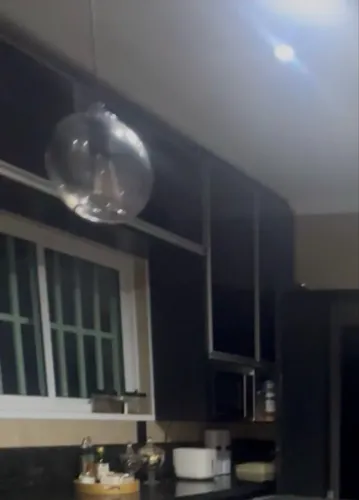 Armário de cozinha preto com porta de vidro contém porta temperos