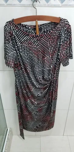 Vestido preto e branco com detalhes em rosa e faixa na cintura.