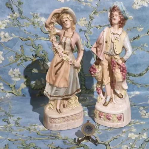 Par de estatuetas antigas em biscuit, de um casal de camponeses.Medem 26 cm.Sem avarias!