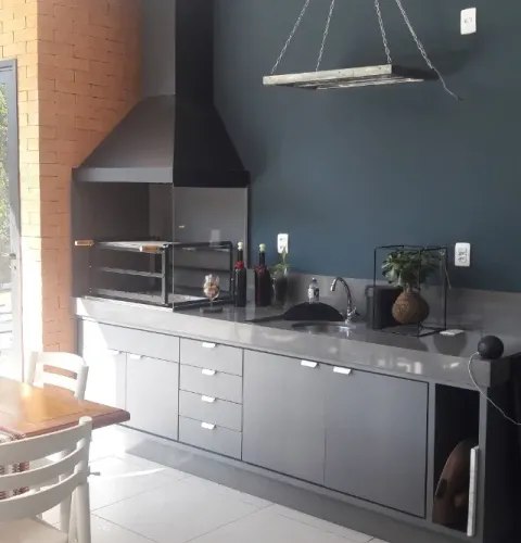 Churrasqueira gourmet com coifa de aço, vidros e braseiro de embutir