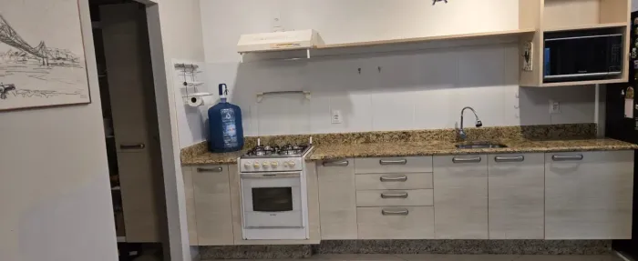 Cozinha completa com armários, fogão e coifa