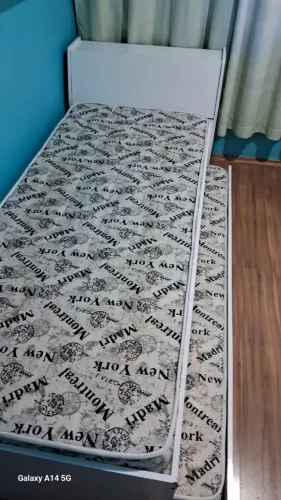 Cama solteiro com cama auxiliar e dois colchões.