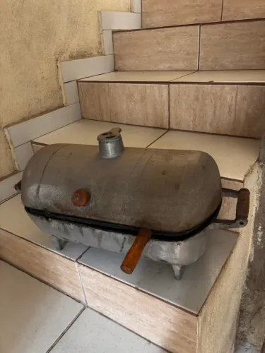 Churrasqueira de alumínio com grelha de ferro.