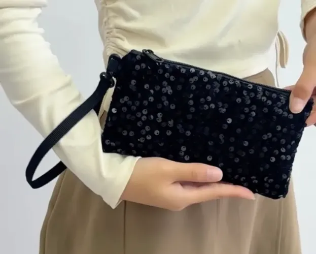 Clutch preta com paetês, Zíper e alça de mão. Dimensões: 20 X 10cm 