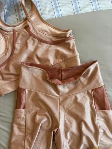 Conjunto fitness femino short e top bege cintilante com detalhes. O short tem bolsos. 