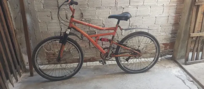 Vende uma bicicleta de cor laranja com marcha