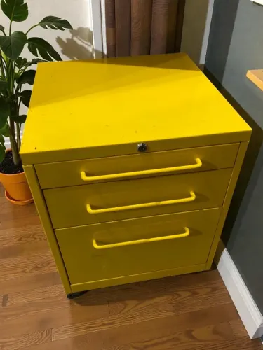 Arquivo amarelo de metal, com 3 gavetas.
