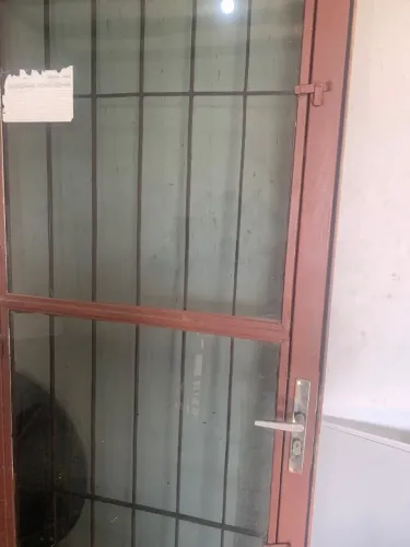 Vendo porta de ferro com vidro escuro e grade medidas 0,70 x 2,10