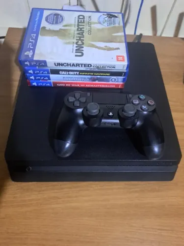PS4 com controle e jogos.