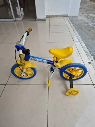 Duas bicicletas aro 12, uma da Shark da Nathor azul e outra track arco-íris rosa