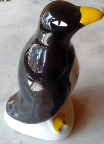Escultura em porcelana esmaltada policromada dita pinguim de geladeira bico e pés amarelos