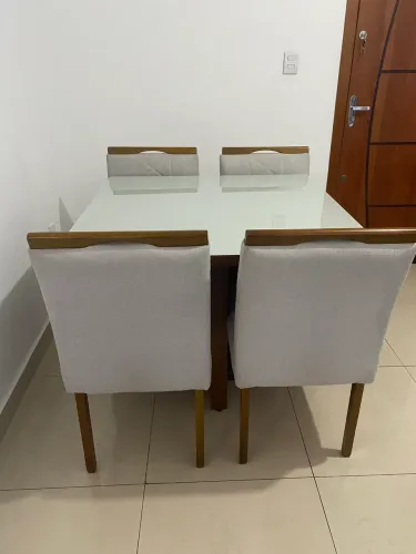 Mesa de jantar com 4 cadeiras estofadas.