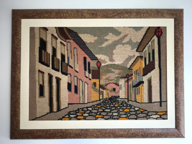 Quadro2 Tapeçaria retrata rua de paralelepípedos em vilarejo