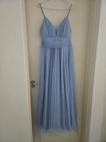 Vestido longo de festa azul serenity apresenta alças finas e um tecido leve de tule.