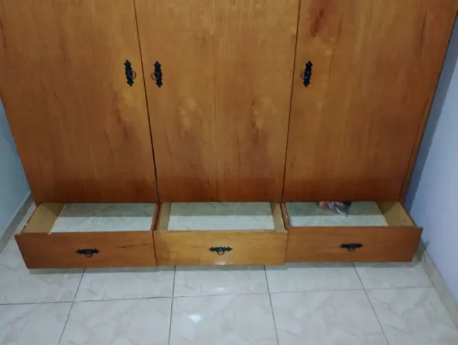 Armario de quarto de três portas e três gavetas mais uma cama em cima.