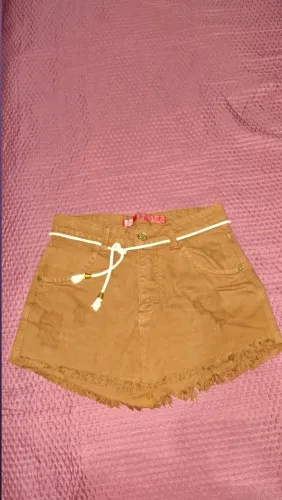 Saia jeans cor caramelo, acompanha um cinto de cordão branco com ponteiras douradas