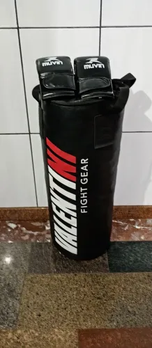 Saco de pancada, caneleira e luvas de box.