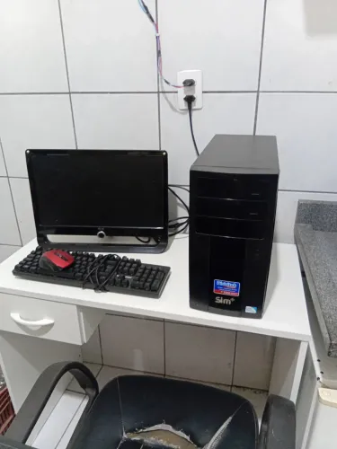 Escrivania, computador e cadeira