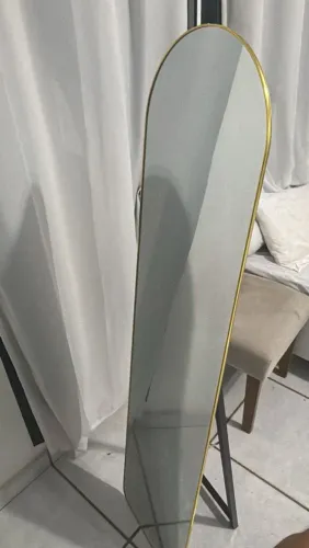 Espelho de corpo inteiro com pé e moldura dourada.