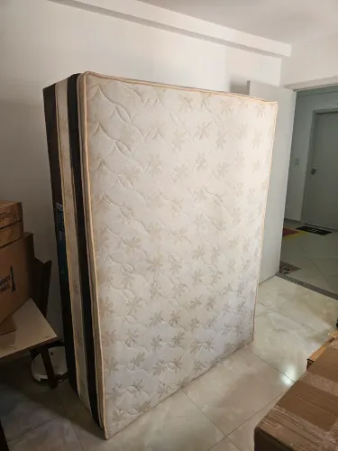 Cama de casal mola ensacada com marcas de uso e de mudanças.