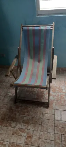 Espreguiçadeira em madeira com apoo para braços.