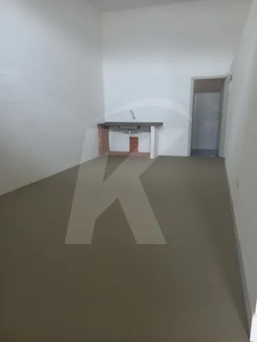 Salão comercial com 1 banheiro e porta de aço.