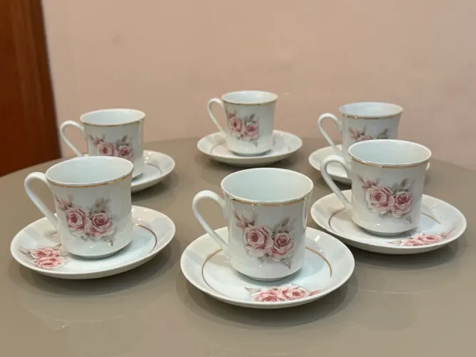 Conjunto de xícaras e pires de porcelana antigos com detalhes florais e dourados