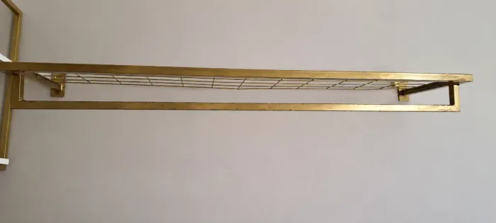 Arara de roupas de parede com prateleira aramada.