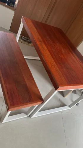 Mesa e banco com tampo de madeira e pés brancos.