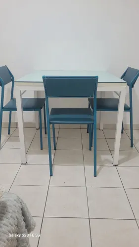 Mesa quadrada de ferro, branca, bade de madeira e vidro. Com 3 cadeiras de ferro azul.