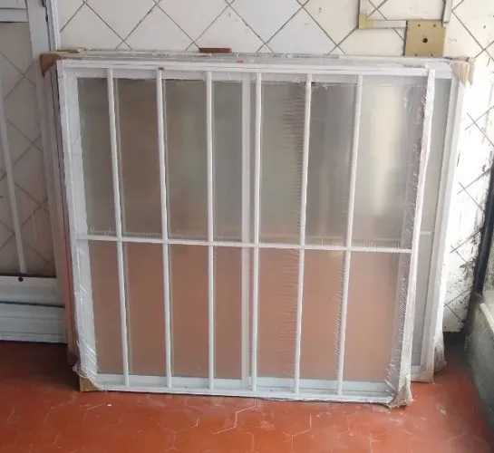 Janela branca de alumínio com grade
