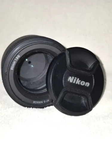 Nikon AF-S 85mm f/1.8G + Lente Nikon 18-55mm de Brinde