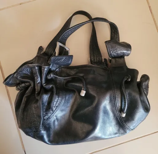 Bolsa de couro preta com detalhes em prata.